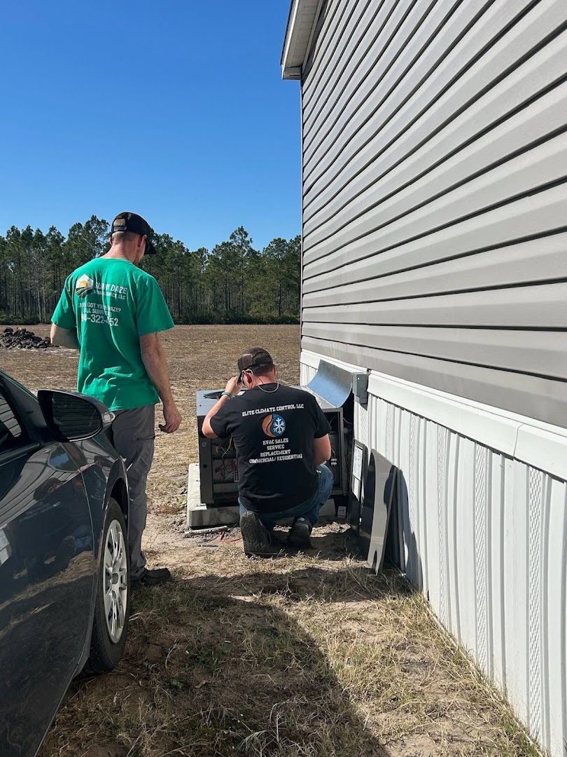 Elite Climate Control technician in a branded shirt servicing an outdoor unit